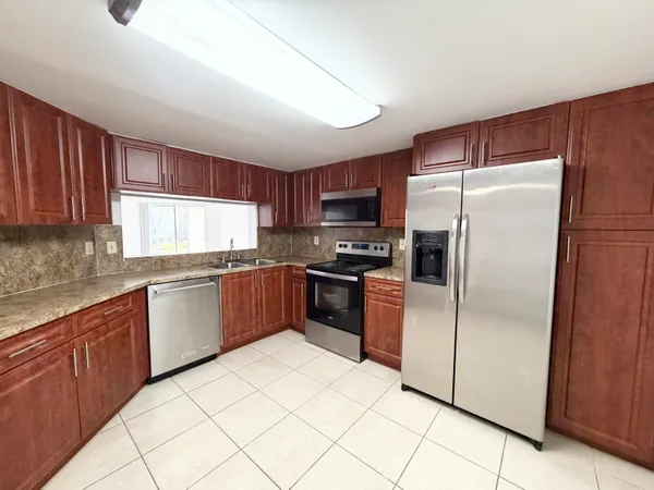 a kitchen with granite countertop a refrigerator and a sink