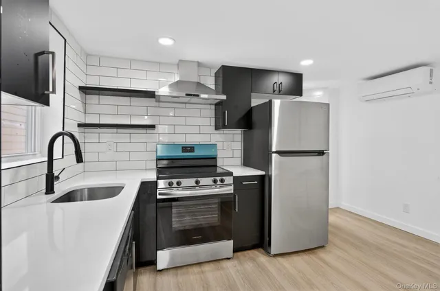 a kitchen with refrigerator a stove and a wooden floor