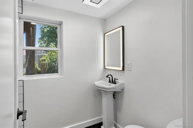a bathroom with a sink mirror and toilet