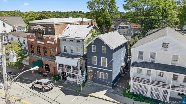 a view of a white house with many windows next to a yard