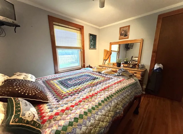 a bedroom with a bed and wooden floor