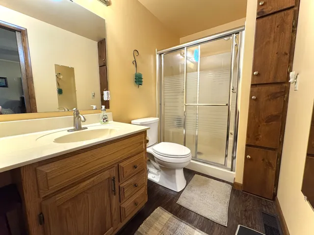 a bathroom with a granite countertop sink toilet and shower