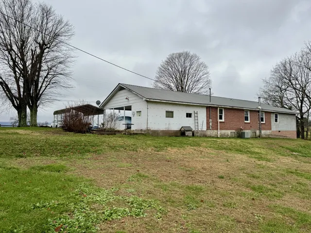 a view of a house with backyard and trees