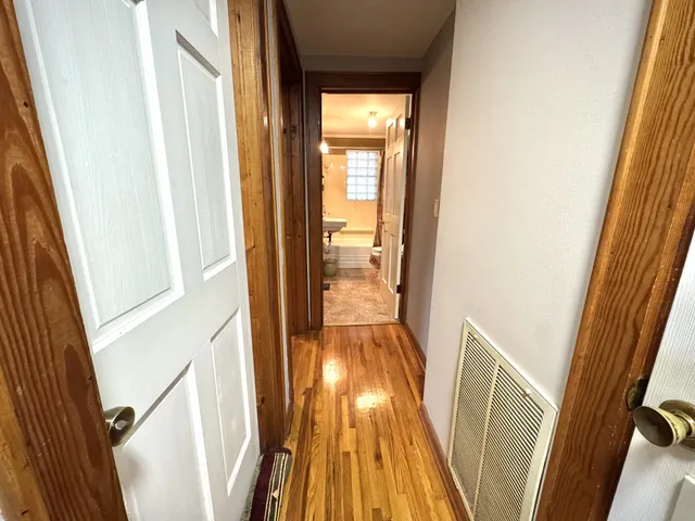 a view of a hallway with wooden floor and stairs
