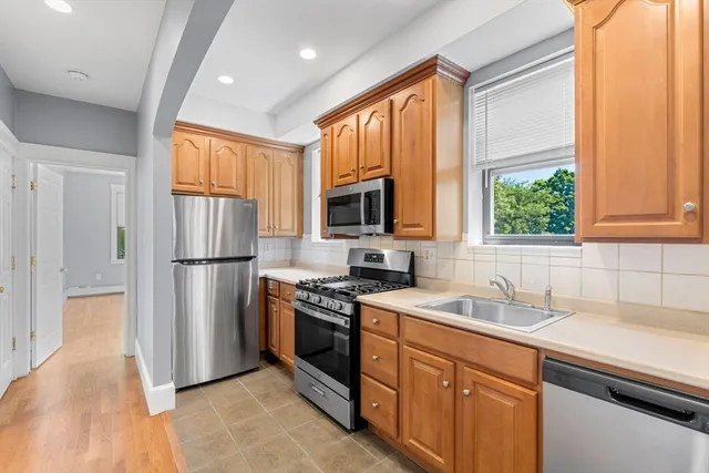 a kitchen with stainless steel appliances granite countertop a refrigerator stove and sink