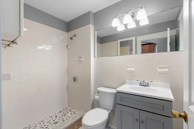 a bathroom with a sink toilet a mirror and shower