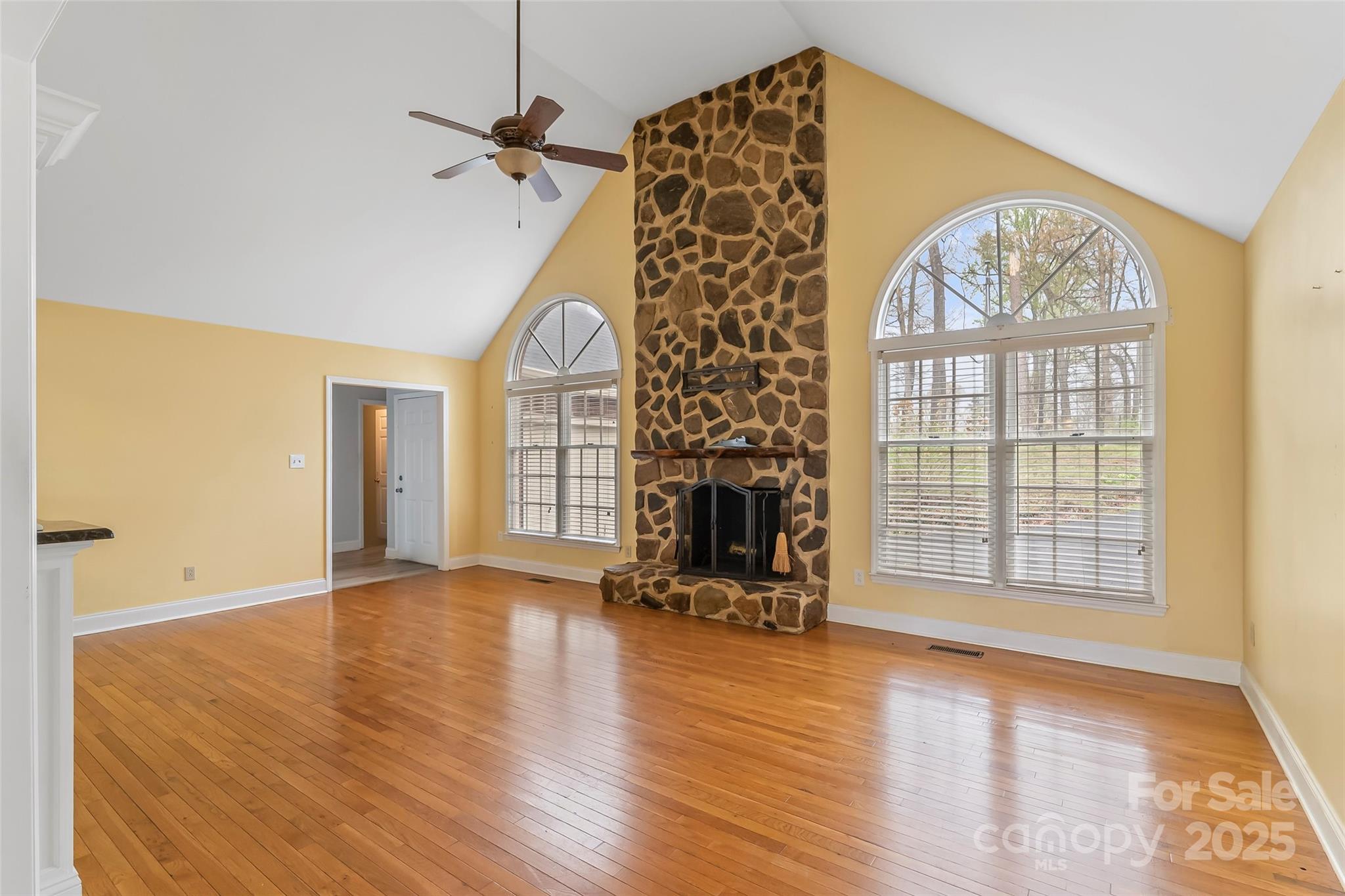 3772 Sandy Ford Road Hickory, NC 28602 - Photo 3 of 32 an empty room with wooden floor a fireplace and windows