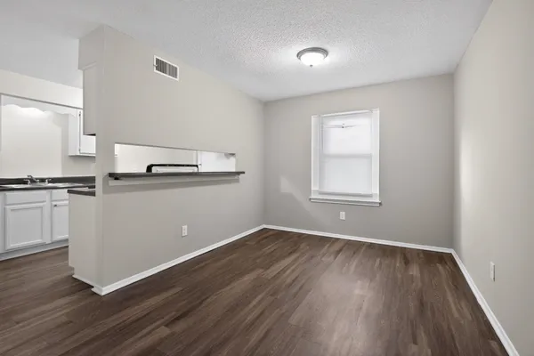 a view of a kitchen with wooden floor and electronic appliances