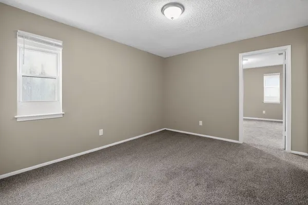 an empty room with windows and closet
