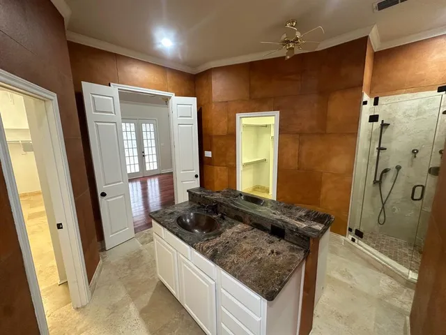 a bathroom with a granite countertop sink a mirror and a shower