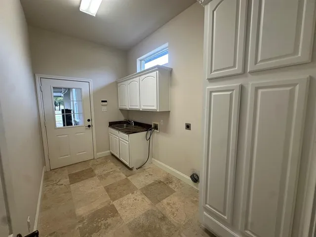 a kitchen with granite countertop a stove a sink and a refrigerator