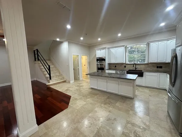 a large white kitchen with lots of counter space a sink and appliances