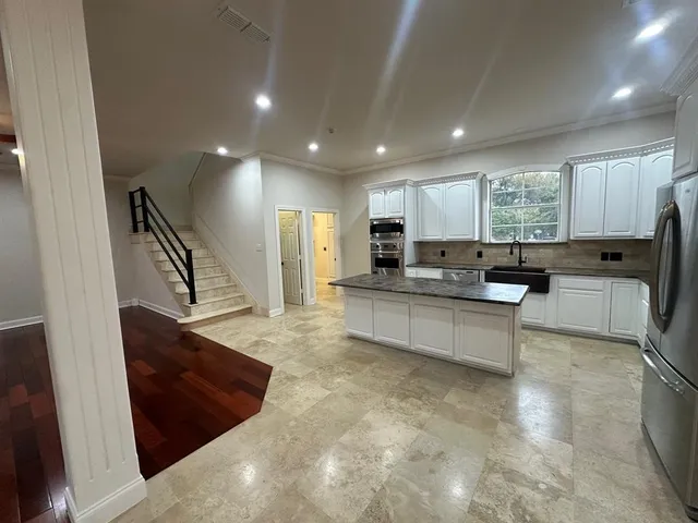 a large white kitchen with lots of counter space a sink and appliances