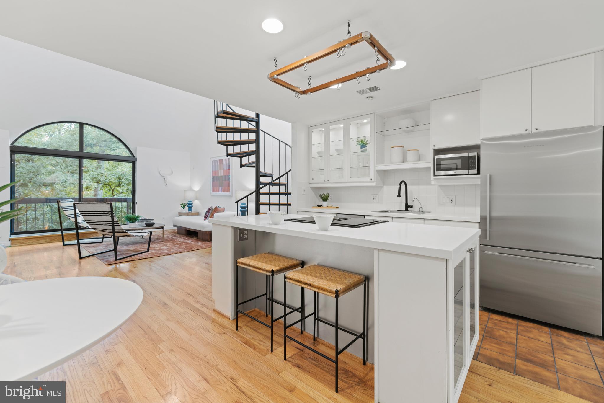 3517 17th Street Northwest, Unit 10 Washington, DC 20010 - Photo 13 of 35 a kitchen with stainless steel appliances granite countertop a stove a sink a refrigerator and white cabinets with wooden floor