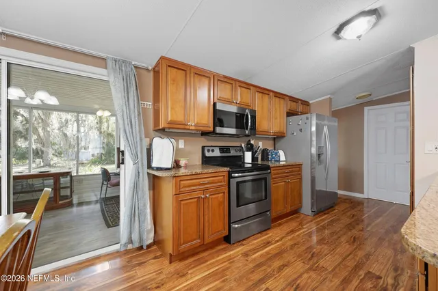 a kitchen with stainless steel appliances granite countertop a refrigerator stove top oven and sink