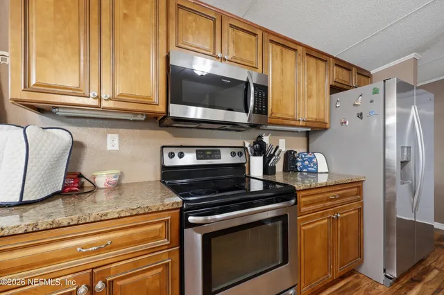 a kitchen with granite countertop cabinets stainless steel appliances and a counter space
