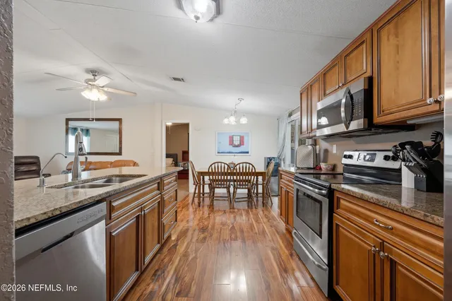a kitchen with granite countertop lots of counter top space a sink and appliances