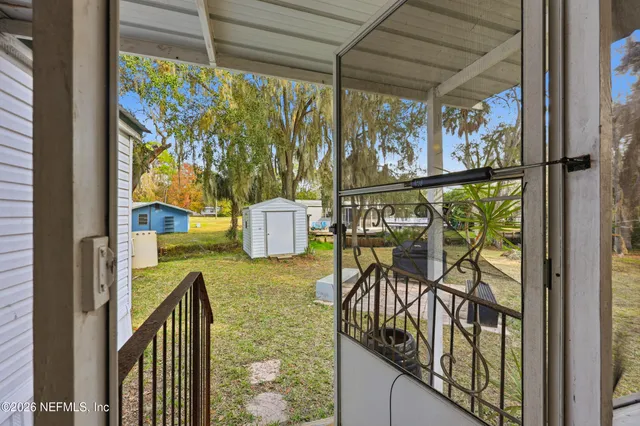 a view of a house with a yard and a large tree