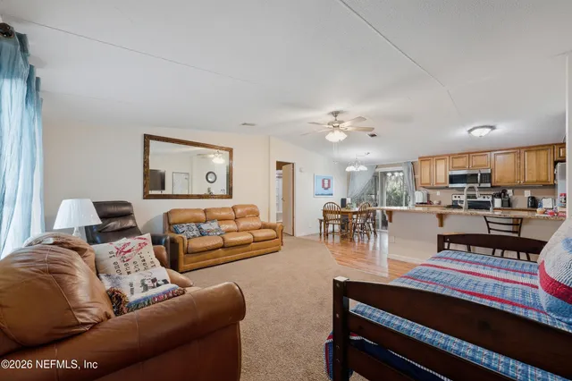 a living room with furniture and view of kitchen