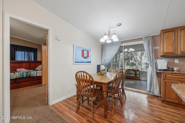 a dining room with furniture a chandelier and wooden floor