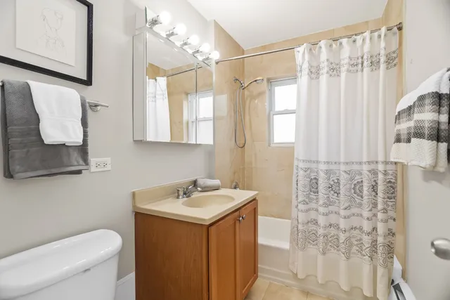 a bathroom with a sink a toilet and shower curtain