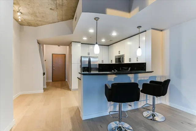 a kitchen with stainless steel appliances granite countertop a refrigerator and a stove top oven