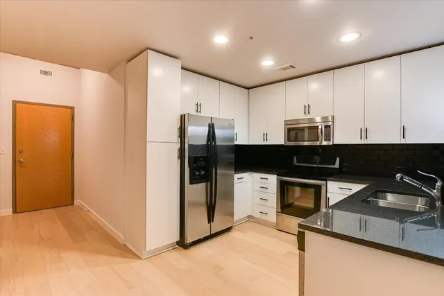 a kitchen with stainless steel appliances a refrigerator and a sink