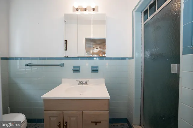 a bathroom with a sink a toilet and mirror