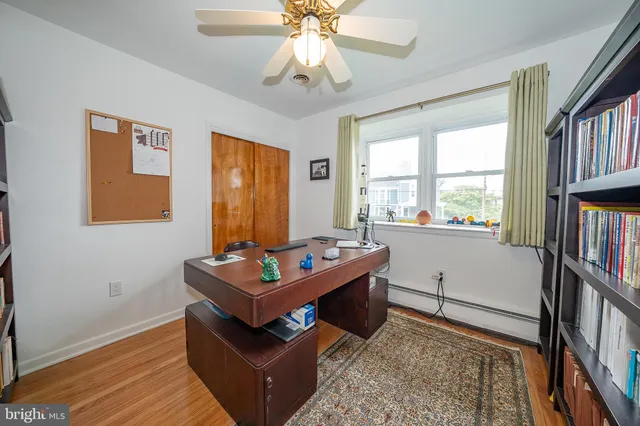 a living room with furniture a bookshelf and a window