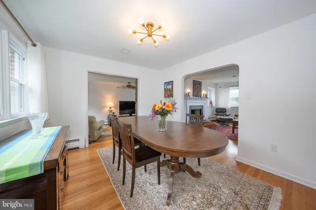 a dining room with furniture a rug a painting and a chandelier