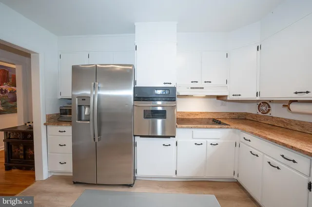 a kitchen with stainless steel appliances granite countertop a refrigerator and a sink