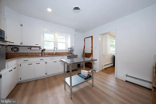 a kitchen with a sink cabinets and wooden floor