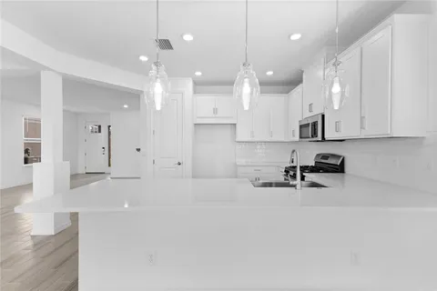 a large white kitchen with cabinets and a wooden floors