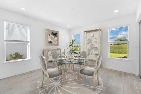 a dining room with furniture a floor to ceiling window and wooden floor