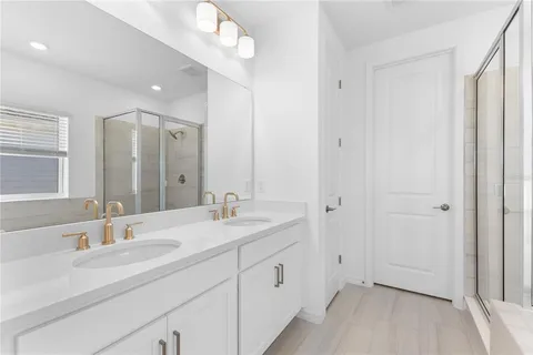 a bathroom with a double vanity sink and mirror