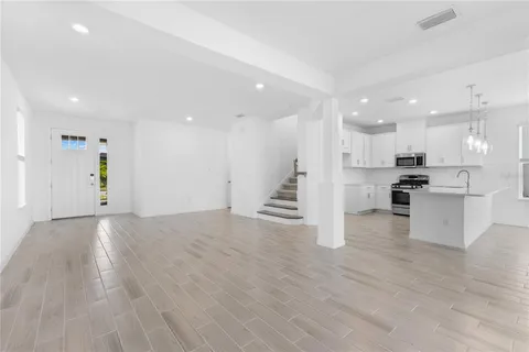 an open kitchen with white cabinets and stainless steel appliances
