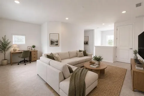 a living room with furniture a rug and a flat screen tv