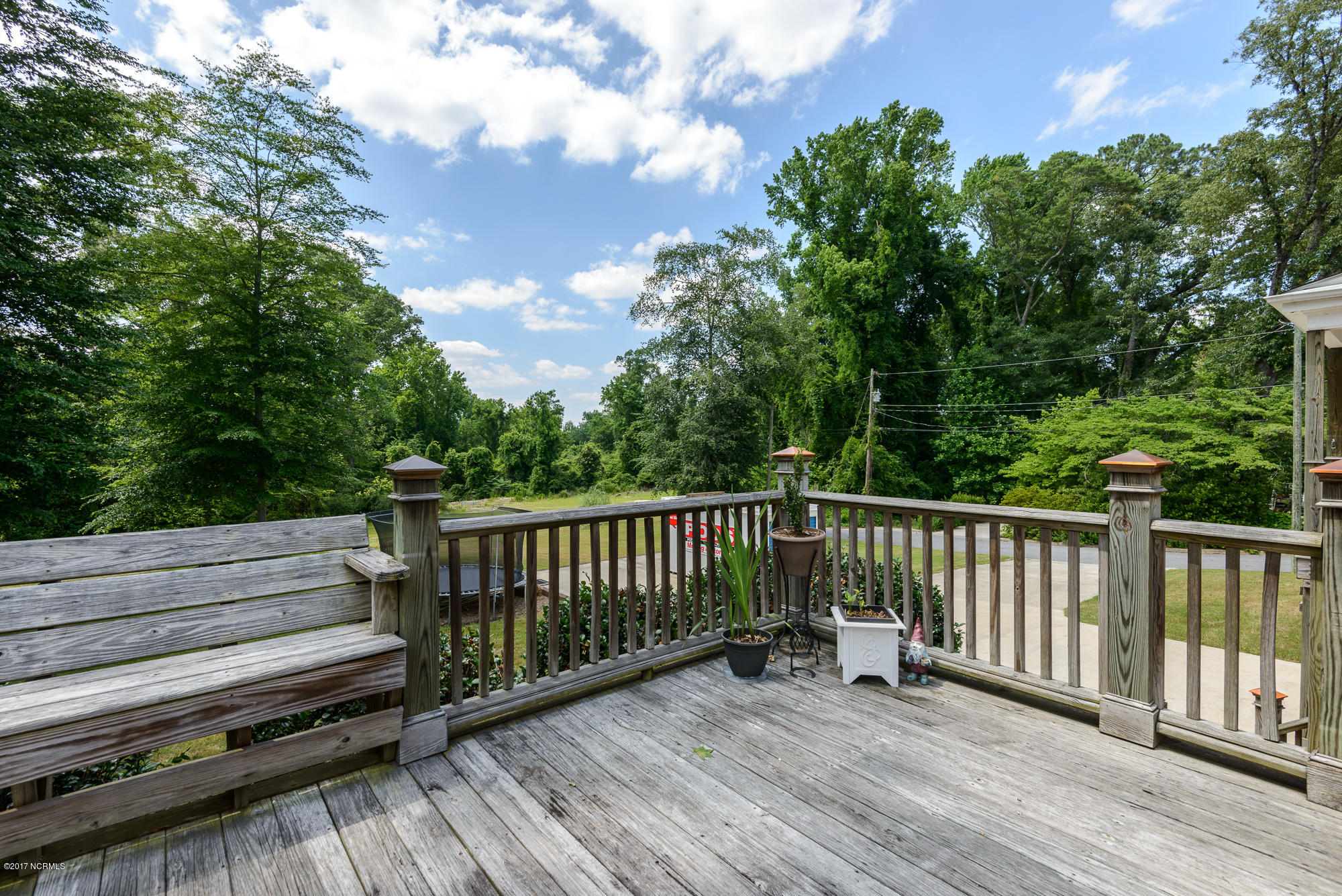 1100 West Rock Spring Road Greenville, NC 27858 - Photo 45 of 51 deck with built-in seating overlooking tree lined backyard