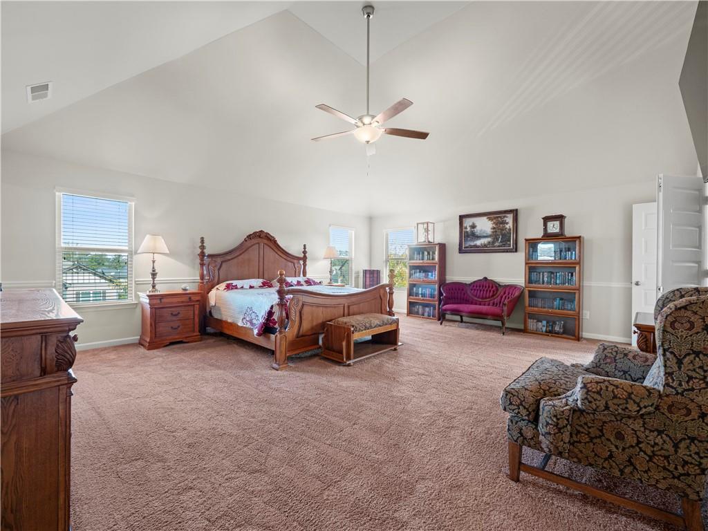 190 Silver Ridge Road Covington, GA 30016 - Photo 27 of 51 a spacious bedroom with a bed and a chandelier