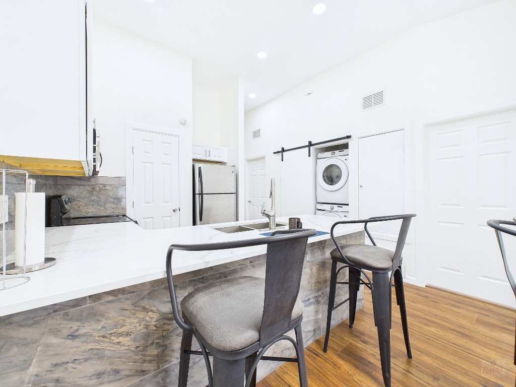 2216 San Gabriel Street, Unit 305 Austin, TX 78705 - Photo 1 of 38 a kitchen with a table chairs and a sink