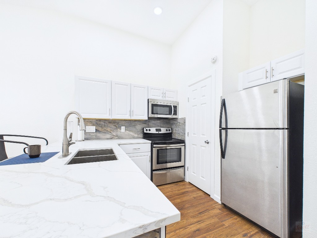 2216 San Gabriel Street, Unit 305 Austin, TX 78705 - Photo 3 of 38 a kitchen with stainless steel appliances a refrigerator stove and microwave