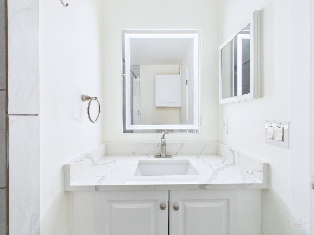 2216 San Gabriel Street, Unit 305 Austin, TX 78705 - Photo 31 of 38 a bathroom with a sink and a mirror