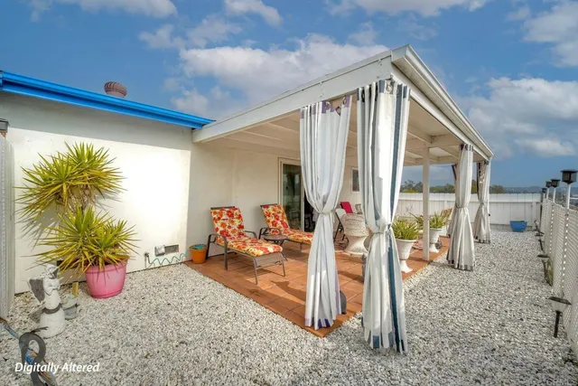 a view of a house with backyard and sitting area