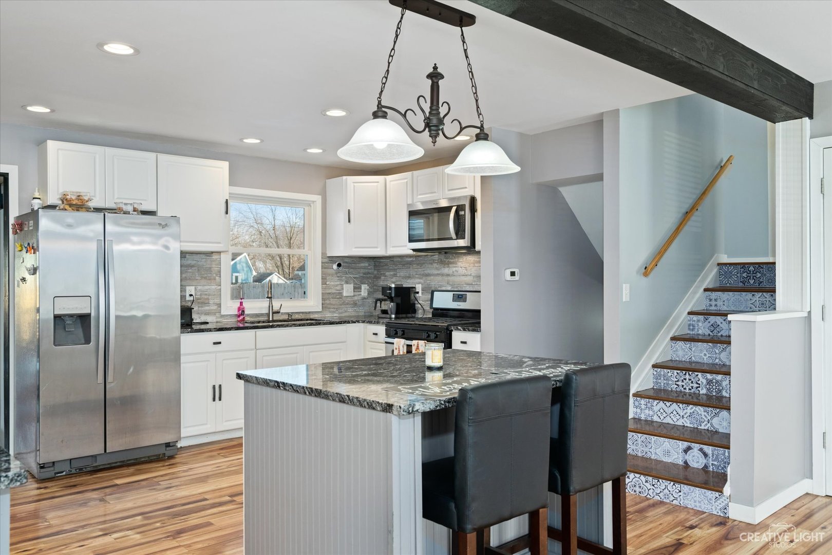 232 Reid Road Genoa, IL 60135 - Photo 3 of 25 a kitchen with stainless steel appliances granite countertop a sink a stove a refrigerator cabinets and a dining table
