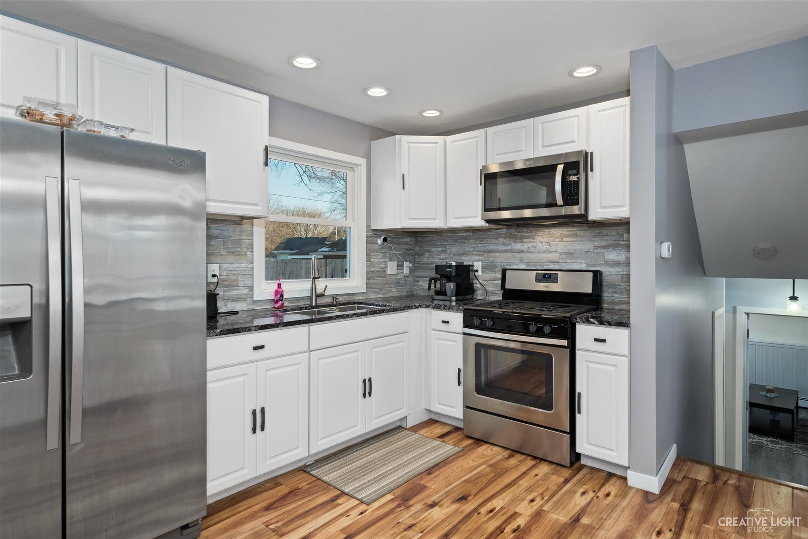 232 Reid Road Genoa, IL 60135 - Photo 4 of 25 a kitchen with stainless steel appliances granite countertop a refrigerator and a stove top oven