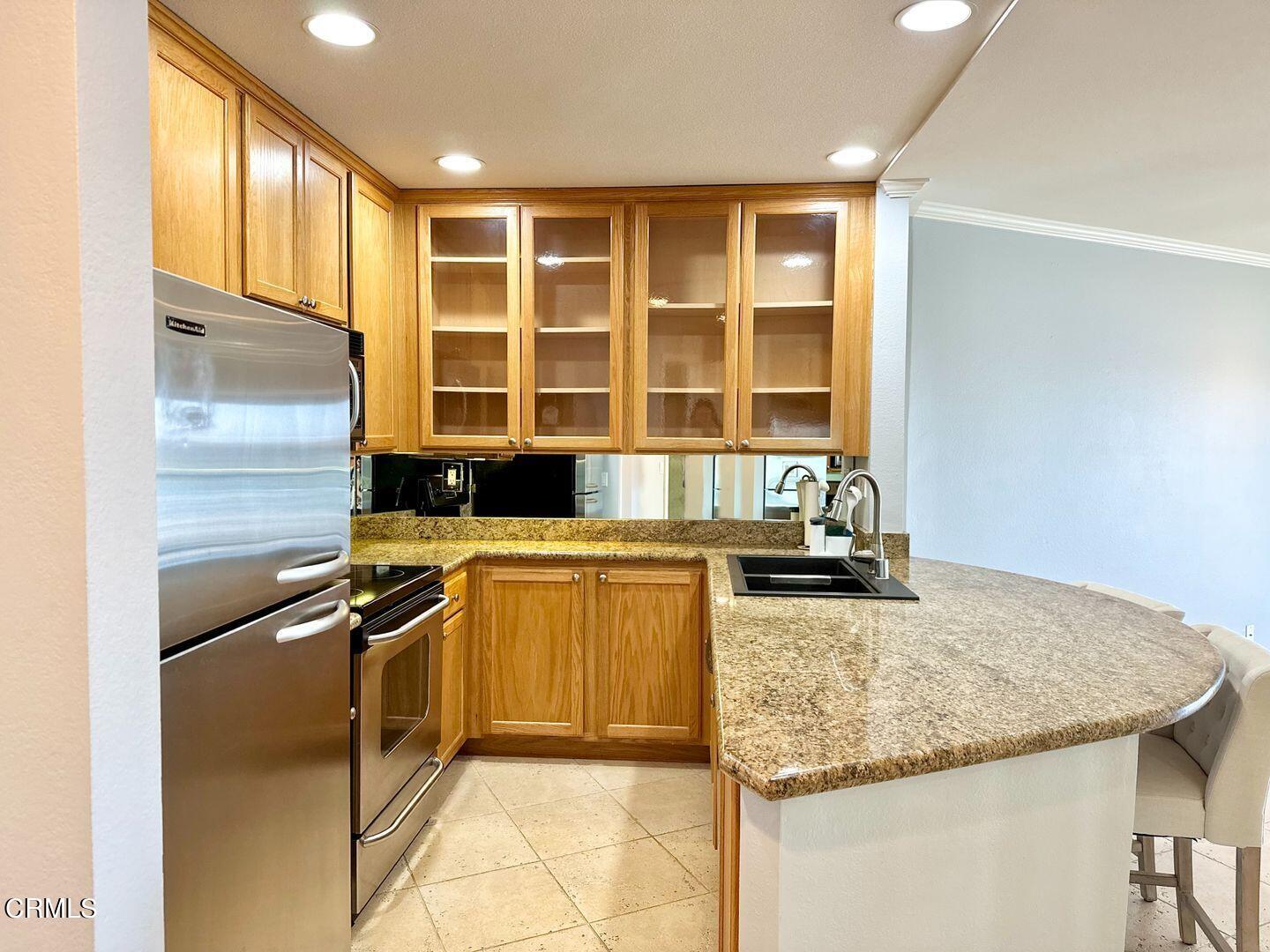 2901 Peninsula Road, Unit 348 Oxnard, CA 93035 - Photo 4 of 22 a kitchen with granite countertop a sink and a refrigerator