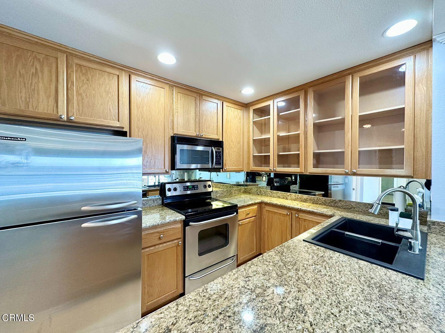 2901 Peninsula Road, Unit 348 Oxnard, CA 93035 - Photo 5 of 22 a kitchen with stainless steel appliances granite countertop a sink stove and microwave