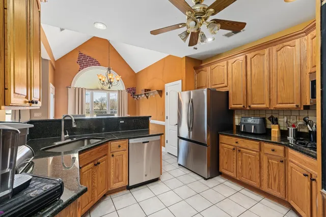 a kitchen with stainless steel appliances granite countertop a sink a stove cabinets and a refrigerator