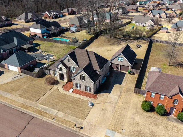 an aerial view of a house with swimming pool and outdoor seating