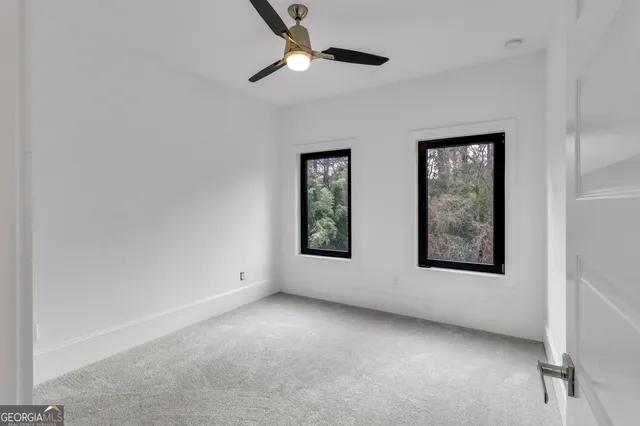 an empty room with windows and fan